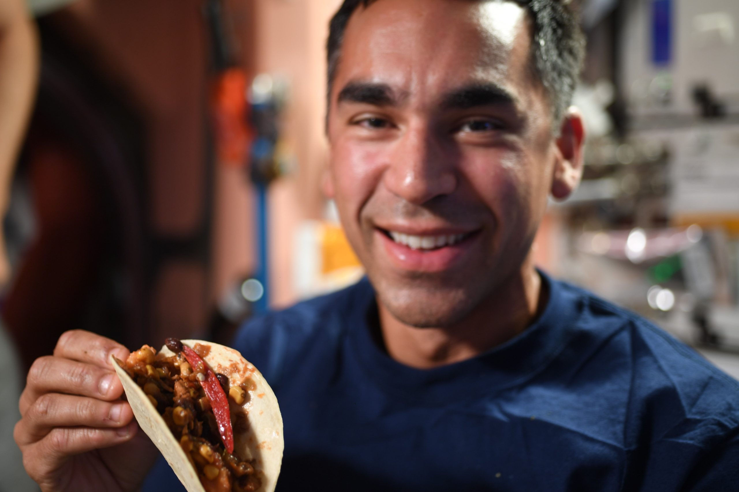 NASA astronaut Raja Chari holds a taco made with freshly harvested chile peppers grown aboard the International Space Station.